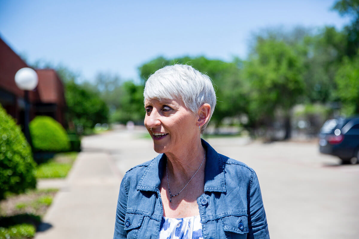 Woman standing in street smiling on a sunny day