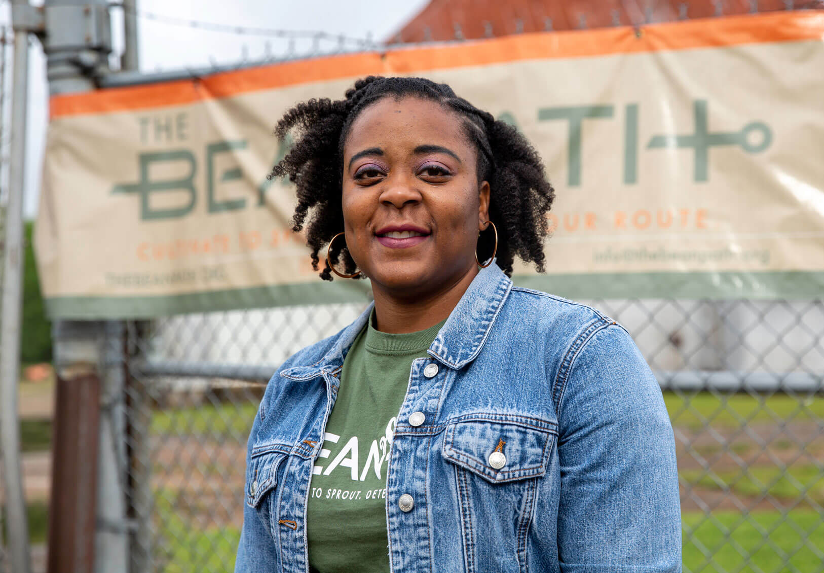 Woman standing and smiling in front of a Bean Path sign